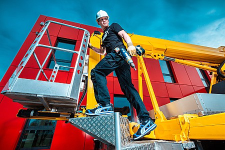 Industriefoto von einem Handwerker auf einer Hebebühne